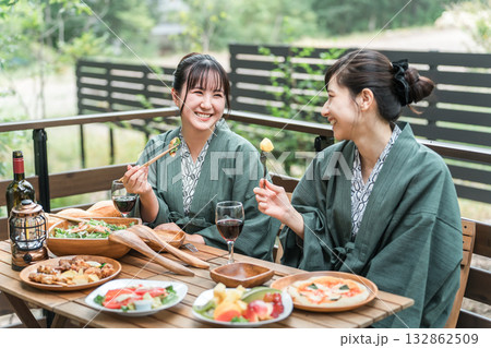 バルコニー・ウッドデッキで食事する旅館・温泉旅館に女子旅に来た若いアジア人女性（旅行・トラベル） 132862509