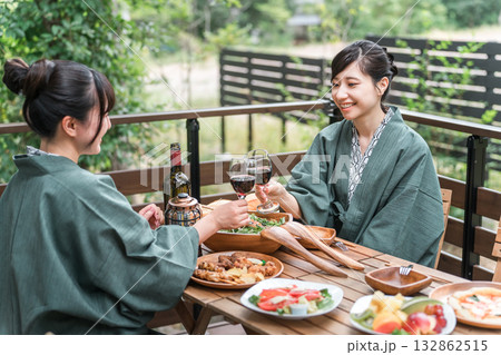 バルコニー・ウッドデッキで食事する旅館・温泉旅館に女子旅に来た若いアジア人女性（旅行・トラベル） 132862515