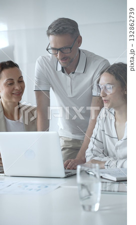 Business people collaborating and analyzing data on a laptop during an office meeting Business people collaborating and analyzing data on a laptop during an office meeting 132862739