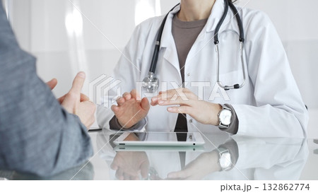 Female doctor consulting patient, explaining treatment options, discussing healthcare in clinic, providing medical advice. Medicine and health care Female doctor consulting patient, explaining treatment options, discussing healthcare in clinic, providing medical advice. Medicine and health care 132862774