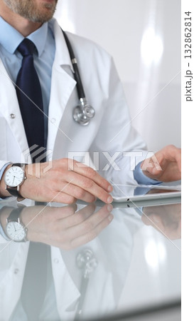 Doctor using tablet computer, providing healthcare consultation, digital medical technology, professional man in lab coat. Medicine and health care Doctor using tablet computer, providing healthcare consultation, digital medical technology, professional man in lab coat. Medicine and health care 132862814
