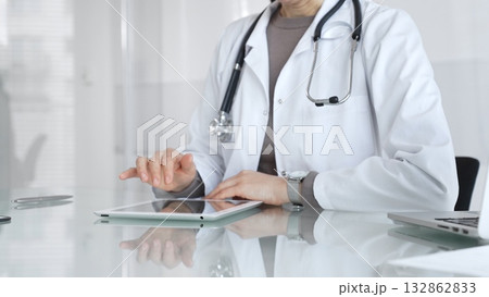 Doctor using digital tablet for remote medical consultation, providing modern healthcare services, telehealth concept. Medicine and health care Doctor using digital tablet for remote medical consultation, providing modern healthcare services, telehealth concept. Medicine and health care 132862833