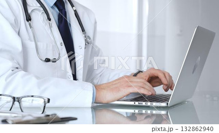 Doctor or healthcare professional using a laptop computer, focusing on telemedicine, digital health records, or medical research. Medicine, healthcare and science concept 132862940
