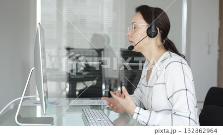 Woman working in call center, providing customer support through headset, communicating in virtual office meeting. Business people concept Woman working in call center, providing customer support through headset, communicating in virtual office meeting. Business people concept 132862964