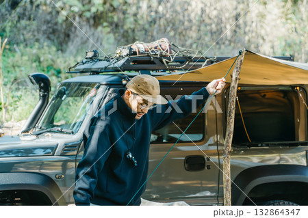秋冬のキャンプ場でテントを設営する男性キャンパー 132864347