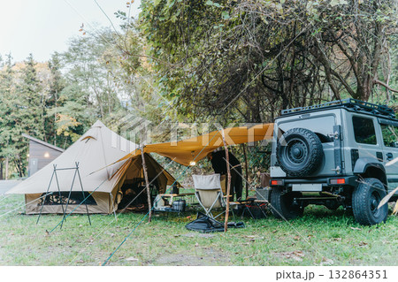 秋冬のキャンプ場でテントを設営する男性キャンパー 秋冬のキャンプ場でテントを設営する男性キャンパー 132864351