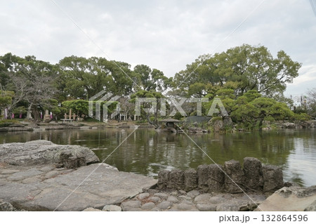 水面に緑が映る池と石灯籠 132864596