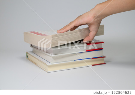 積まれた本と手に触れる動作 132864625