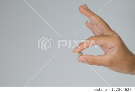 指先で小さな石をつまむ 132864627