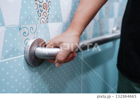 Asian elderly old woman patient use toilet support rail in bathroom, handrail safety grab bar, security in nursing hospital. 132864665