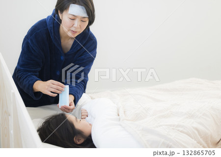 熱を出した小学生の女の子とお母さん 熱を出した小学生の女の子とお母さん 132865705