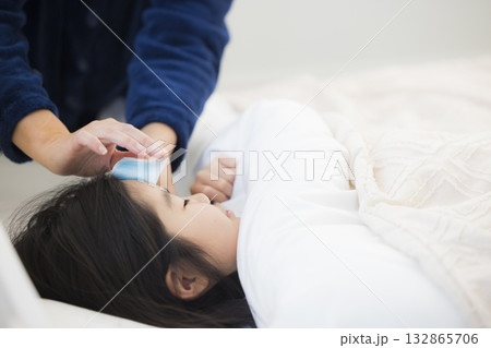 熱を出した小学生の女の子とお母さん　 132865706