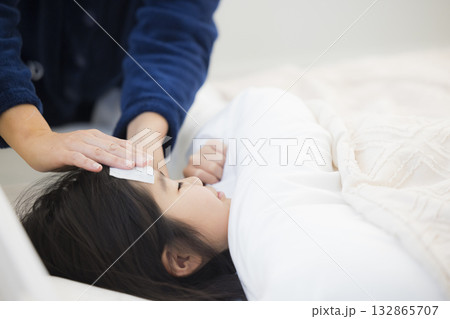 熱を出した小学生の女の子とお母さん 熱を出した小学生の女の子とお母さん 132865707