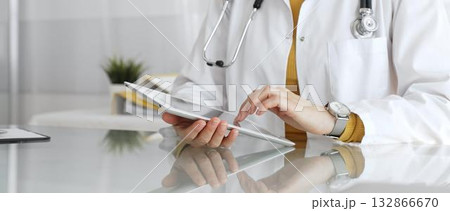 Female doctor using digital tablet, providing modern healthcare and medical technology consultation. Medicine, healthcare and science concept Female doctor using digital tablet, providing modern healthcare and medical technology consultation. Medicine, healthcare and science concept 132866670
