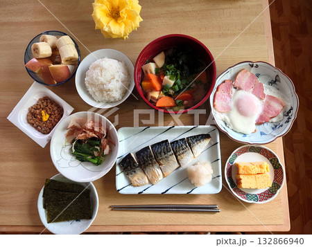 町の日本食レストランで食べる焼き魚定食のセットメニュー(鯖の塩焼き，玉子料理，青菜の小皿，豚汁ほか) 132866940