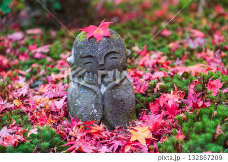 Smile Jizo Buddha stone statue with red maple leaf, Enko-ji temple, Kyoto Smile Jizo Buddha stone statue with red maple leaf, Enko-ji temple, Kyoto 132867209