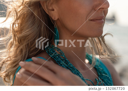 Woman beach summer, serene profile of a blonde woman wearing turquoise jewelry on a sunny outdoor day 132867720