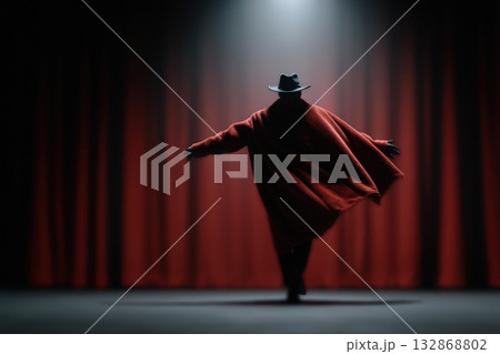 Old theater actor performs dramatically in front of red curtains under spotlight 132868802