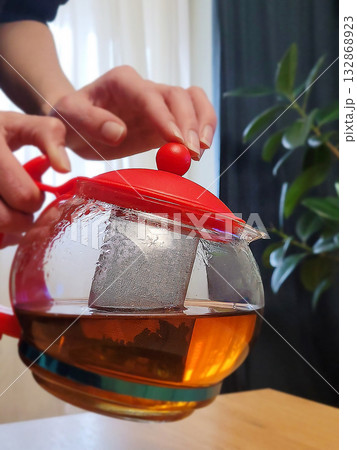 Hand Holding Glass Teapot with Red Lid Hand Holding Glass Teapot with Red Lid 132868923