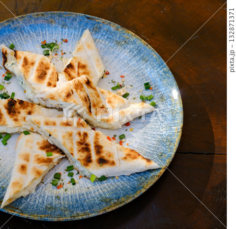 Grilled cheese triangles of grilled triangle sandwiches with cheese and sausage on a plate on a table top view Grilled cheese triangles of grilled triangle sandwiches with cheese and sausage on a plate on a table top view 132871371