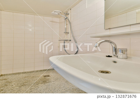 A sleek, modern bathroom showcasing a white sink and contemporary shower setup, emphasizing clean lines and minimalistic design. A sleek, modern bathroom showcasing a white sink and contemporary shower setup, emphasizing clean lines and minimalistic design. 132871676