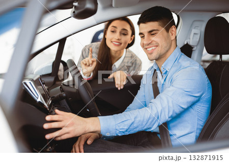Young Wife Helping Husband Choose New Family Car Buying Auto In Dealership Shop. Selective Focus Young Wife Helping Husband Choose New Family Car Buying Auto In Dealership Shop. Selective Focus 132871915