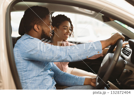 Test Drive. Happy Afro Spouses Sitting In Car Choosing Family Auto In Dealership Showroom. Selective Focus Test Drive. Happy Afro Spouses Sitting In Car Choosing Family Auto In Dealership Showroom. Selective Focus 132872404
