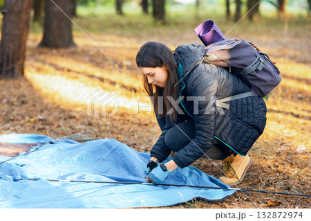 Young woman setting tent in camp, backpacking at countryside, copy space Young woman setting tent in camp, backpacking at countryside, copy space 132872974