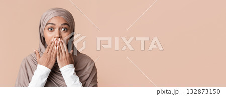 Happy Shock. Astonished black muslim woman in hijab covering her mouth with hands, standing over yellow background with free space Happy Shock. Astonished black muslim woman in hijab covering her mouth with hands, standing over yellow background with free space 132873150