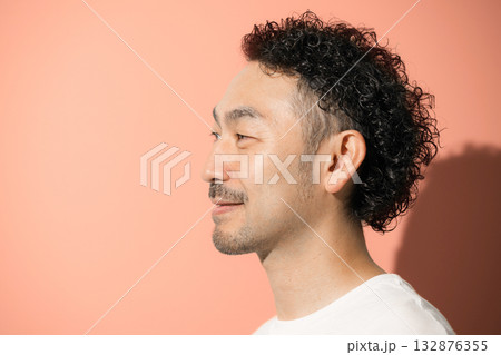 オレンジ背景で横顔のミドル男性クローズアップ 132876355