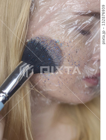 Microplastics in cosmetics. A woman applied a care cream to her skin, now it is covered with plastic particles and microbeads. Cosmetics toxicity concept 132876939
