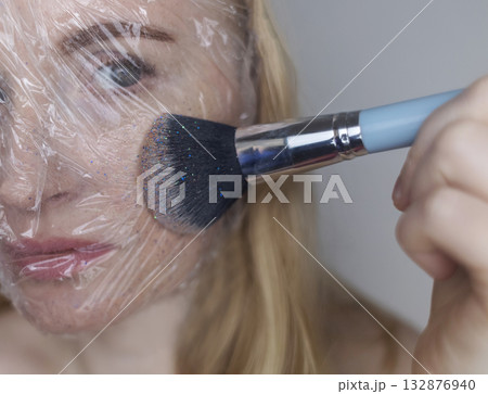 Microplastics in cosmetics. A woman applied a care cream to her skin, now it is covered with plastic particles and microbeads. Cosmetics toxicity concept Microplastics in cosmetics. A woman applied a care cream to her skin, now it is covered with plastic particles and microbeads. Cosmetics toxicity concept 132876940