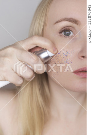 Microplastics in cosmetics. A woman applied a care cream to her skin, now it is covered with plastic particles and microbeads. Cosmetics toxicity concept 132876945