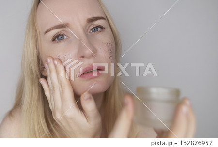 Microplastics in cosmetics. A woman applied a care cream to her skin, now it is covered with plastic particles and microbeads. Cosmetics toxicity concept Microplastics in cosmetics. A woman applied a care cream to her skin, now it is covered with plastic particles and microbeads. Cosmetics toxicity concept 132876957