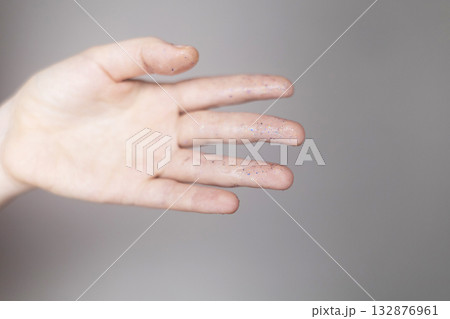 Microplastics in cosmetics. A woman applied a care cream to her skin, now it is covered with plastic particles and microbeads. Cosmetics toxicity concept 132876961