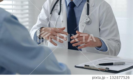 Medical professional explaining diagnosis, gesturing hands to patient during consultation in well lit clinical setting. Medicine and health care concept 132877526