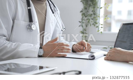Doctor man is explaining diagnosis to female patient during a medical consultation in a medical office, gesturing with hands. Medicine and health care Doctor man is explaining diagnosis to female patient during a medical consultation in a medical office, gesturing with hands. Medicine and health care 132877555