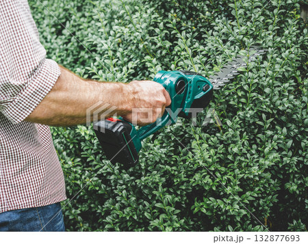 Attractive man, work clothes and hedge trimmer 132877693