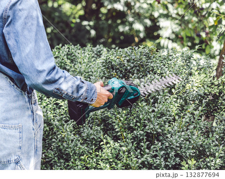 Cute woman, work clothes and hedge trimmer Cute woman, work clothes and hedge trimmer 132877694