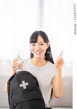 防災リュックを持つ若い女性 132877737