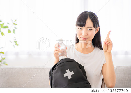 防災リュックを持つ若い女性 132877740