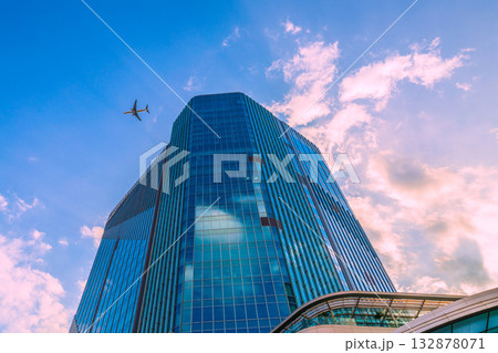 日本の東京都市景観高輪ゲートウェイ駅前の高輪ゲートウェイシティなどを望む。上空に航空機(E連続写真） 132878071