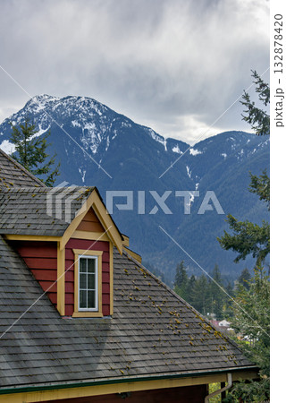 Top of residential house with mountain view and overcast sky background 132878420