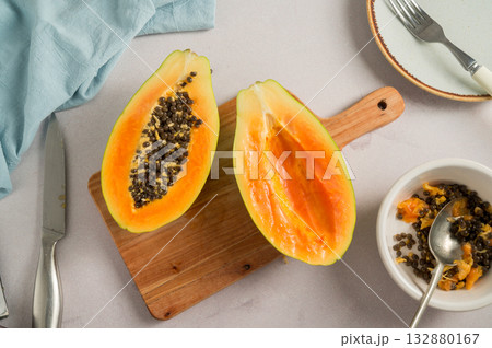 Papaya orange fruit cutted in halves, bright food photo, top view Papaya orange fruit cutted in halves, bright food photo, top view 132880167