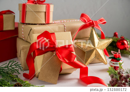 Festive Christmas craft gift boxes with red bows on bright background, Christmas background Festive Christmas craft gift boxes with red bows on bright background, Christmas background 132880172