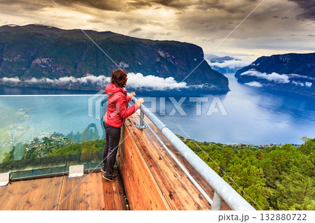 Tourist enjoying fjord view on Stegastein viewpoint Norway Tourist enjoying fjord view on Stegastein viewpoint Norway 132880722