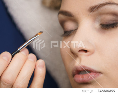 Woman getting eyes make up done by artist 132880855