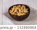 Whole Peanuts in Coconut Bowl on Wooden Table Close-up 132880868