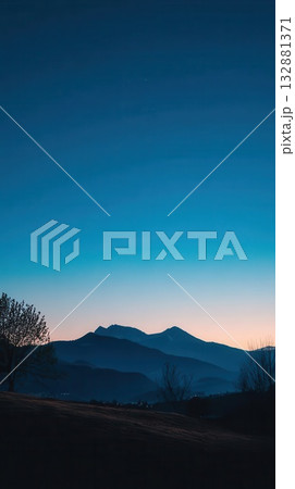 Mountain Silhouettes at Dusk with Blue Sky 132881371