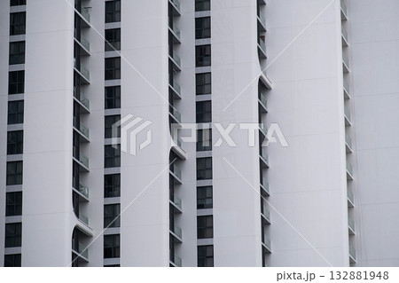 Modern white apartment building facade with dark windows and balconies. Modern white apartment building facade with dark windows and balconies. 132881948